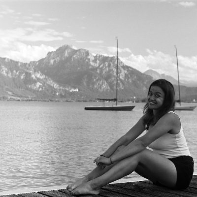 Nicolle am Steg der Forggensee Yachtschule mit dem Dyas-Bojenfeld und den Alpen  im Hintergrund
